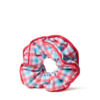 A fabric scrunchie with a pink, light blue, and white gingham pattern, finished with a contrasting red braided rope trim, shown on a plain white background.